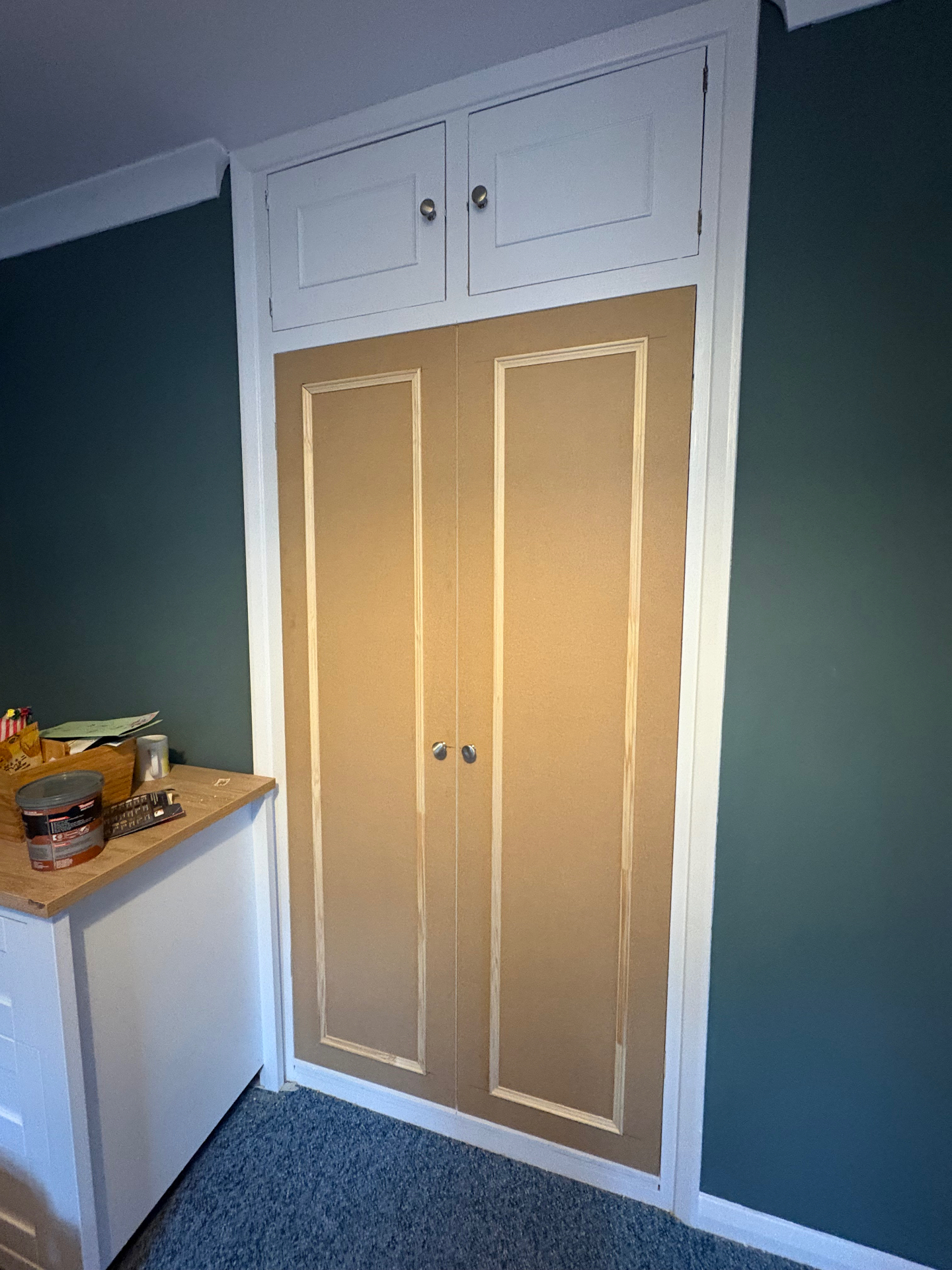 Bespoke alcove cupboard with tall panelled doors and overhead storage in raw MDF