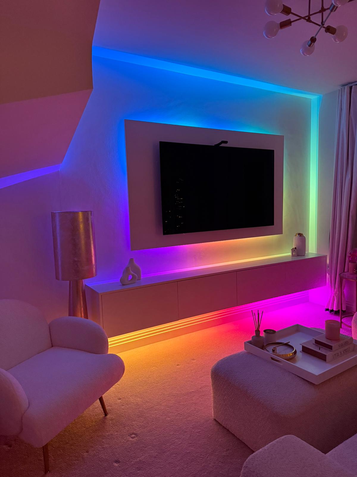 Media wall lit with RGB LED backlighting around the TV and floating cabinet