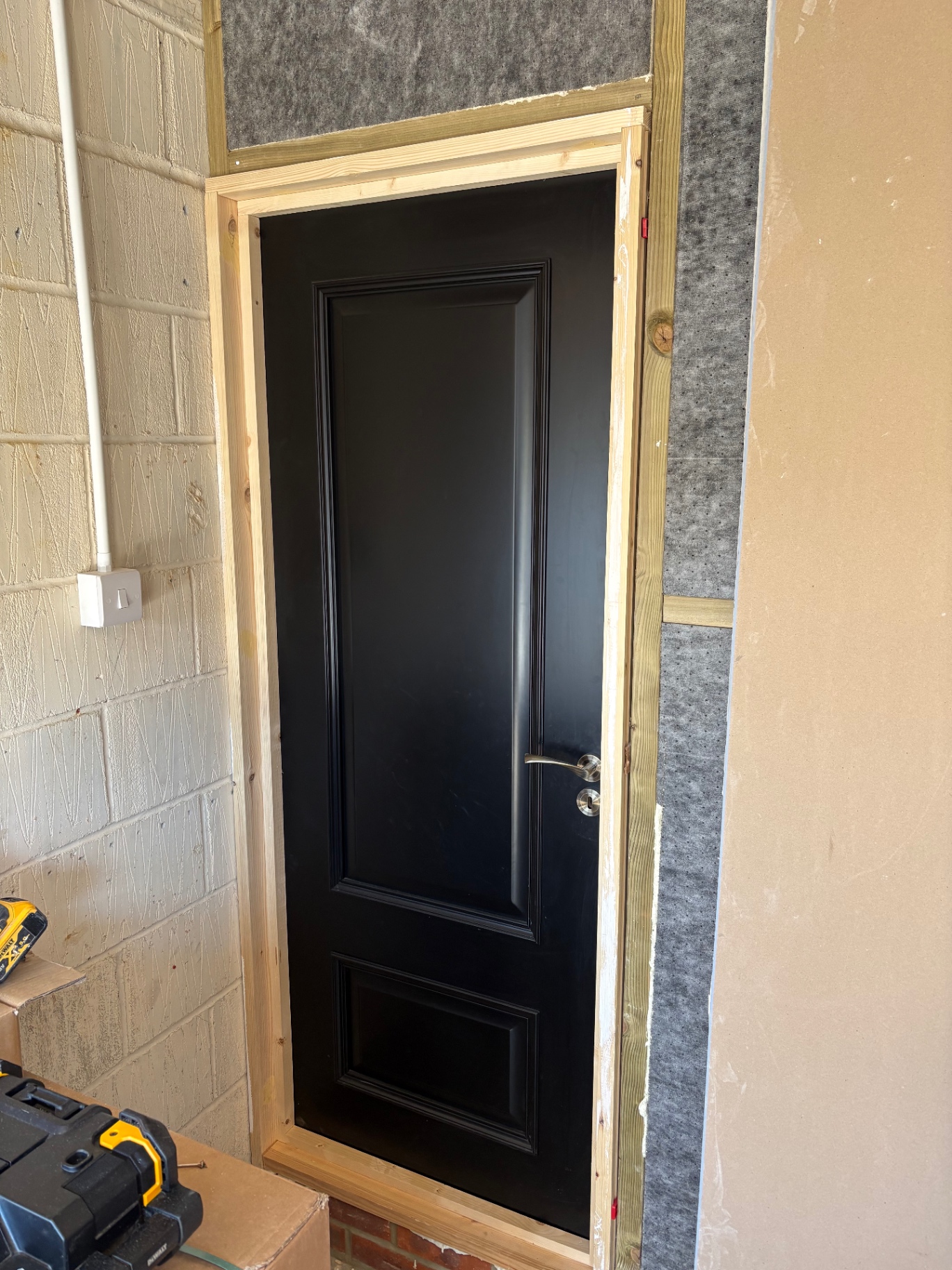 Black panelled door during workshop-style installation