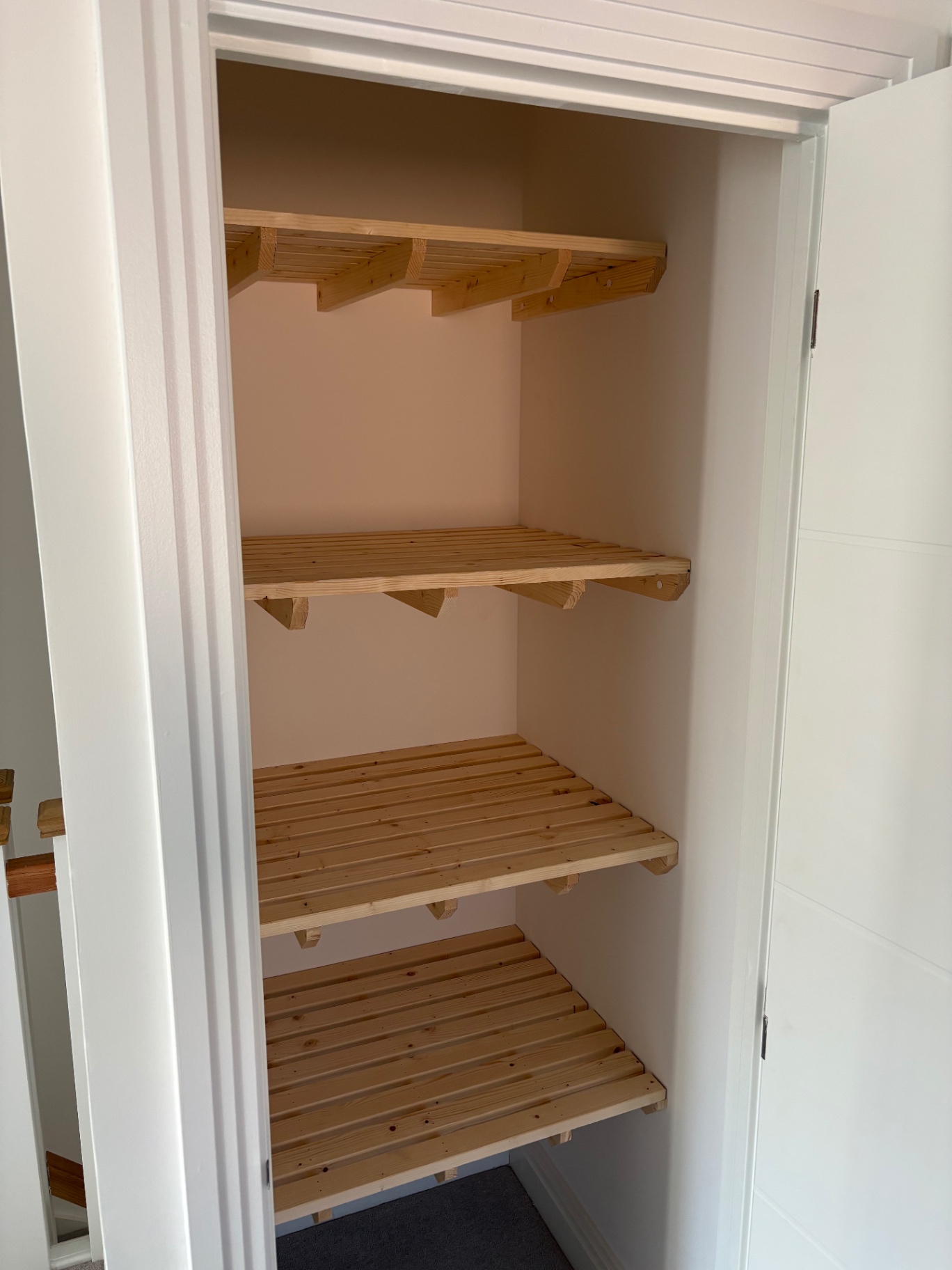 Bespoke pine slatted shelving fitted inside a tall airing cupboard
