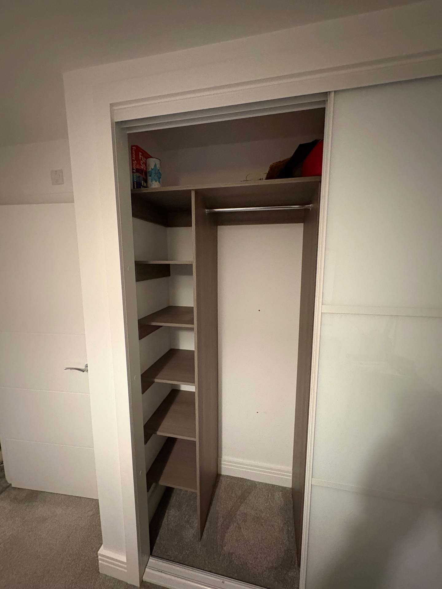 Bespoke sliding wardrobe interior with corner shelving tower and full-length hanging rail