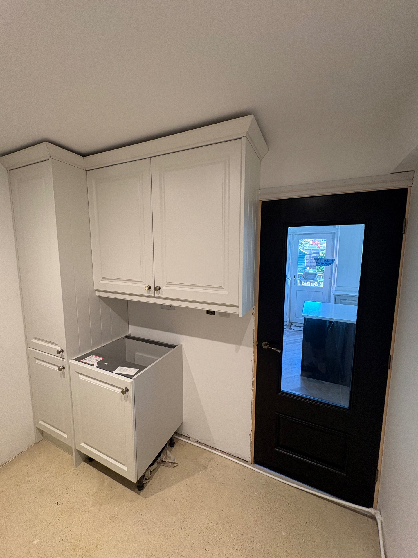 Utility room cabinet installation with black glazed door