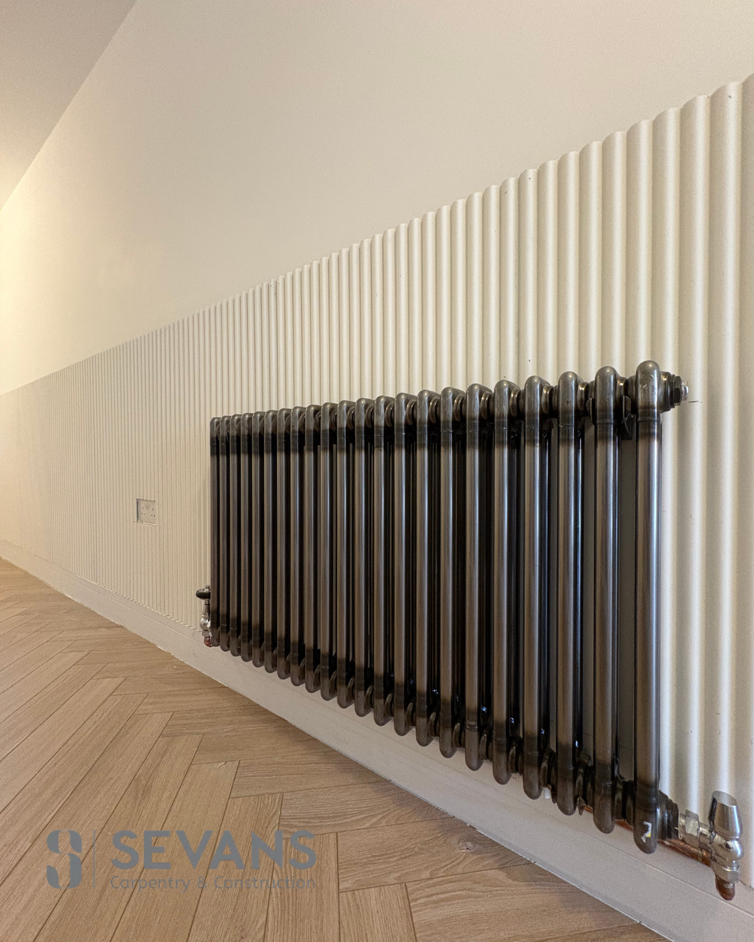 Fluted wall panelling detail behind a dark traditional radiator