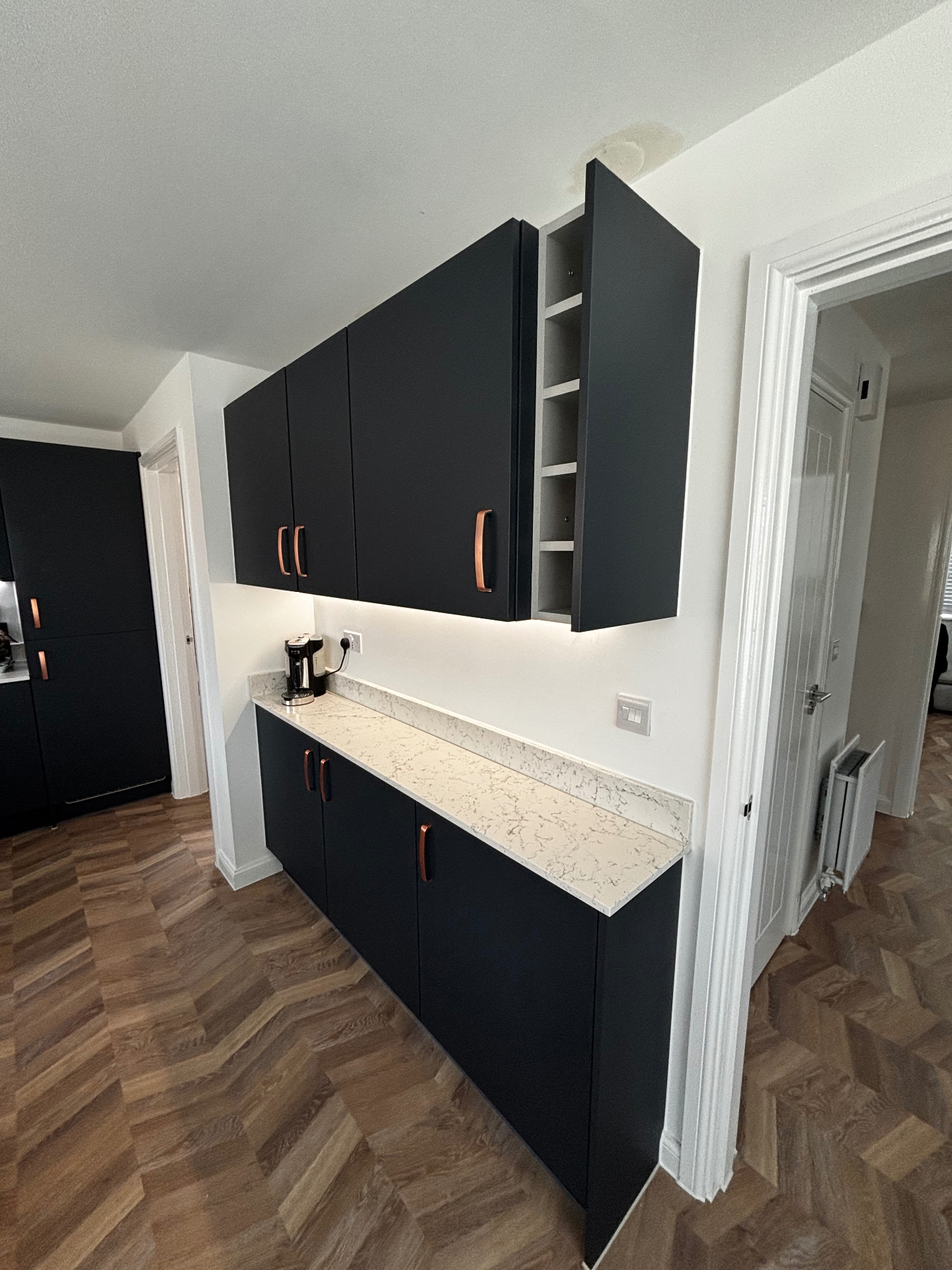 Navy handleless kitchen with copper handles and quartz worktop