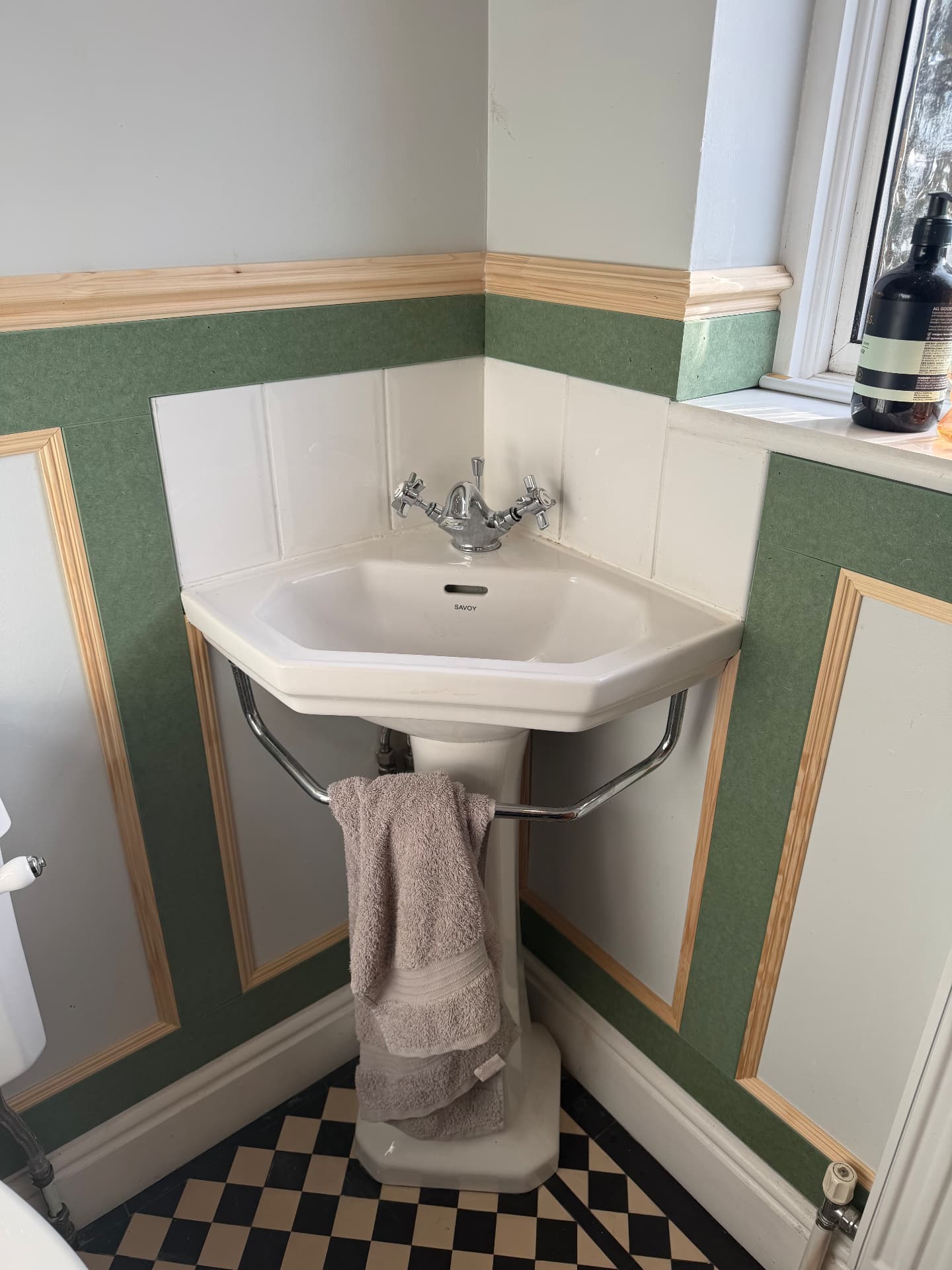 Dado rail mitred and framed around a corner pedestal basin in a cloakroom