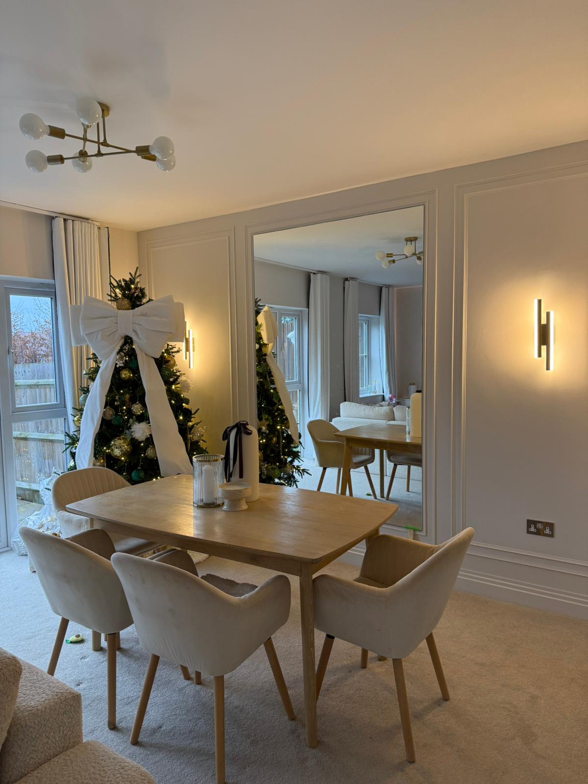 Dining space with decorative wall panelling, oversized mirror and wall lights