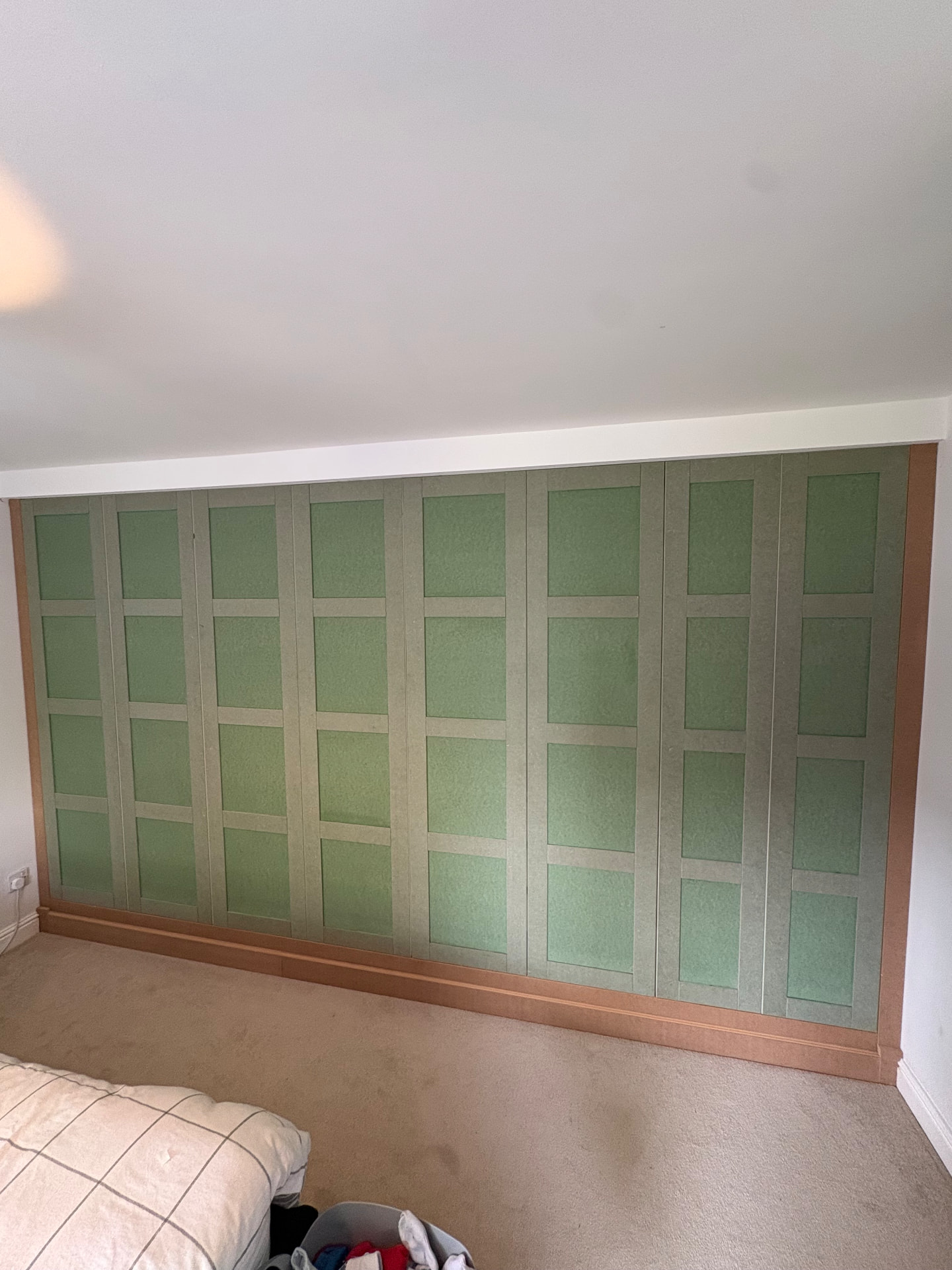 Six-door shaker fitted wardrobe in raw MDF with green moisture-resistant centre panels, ready for primer and paint